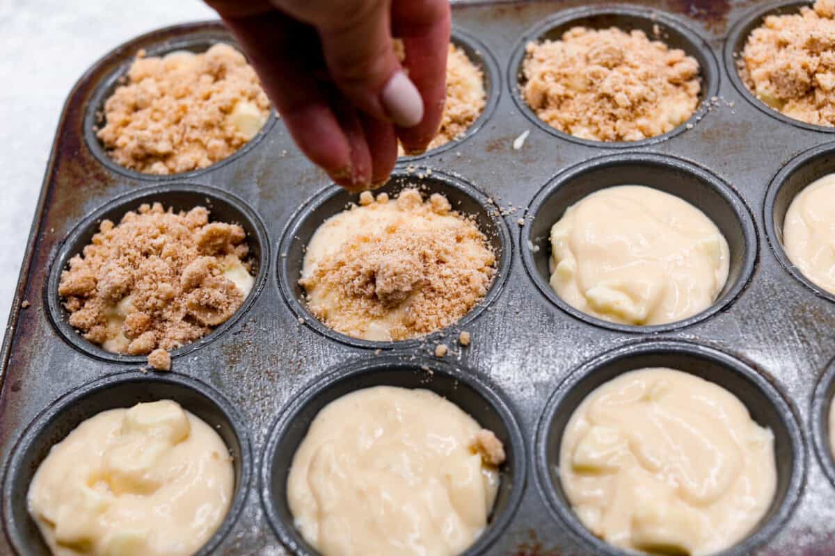 Sixth photo of the crumb topping sprinkling on top of the muffin batter.