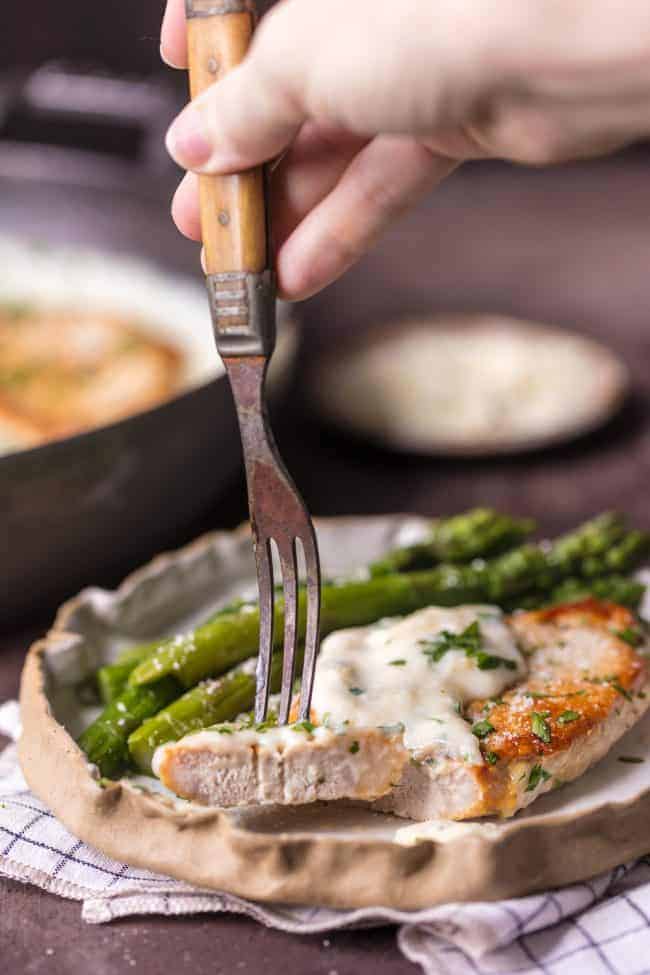 A bite of Creamy Parmesan Pork Chops.