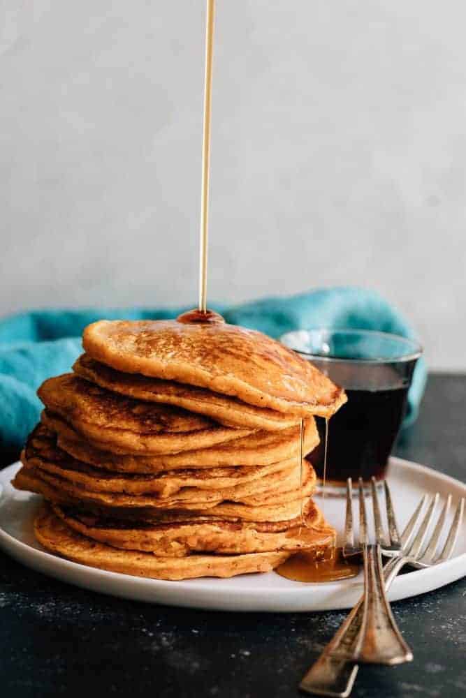 Maple Sweet Potato Pancakes stacked on a white plate.