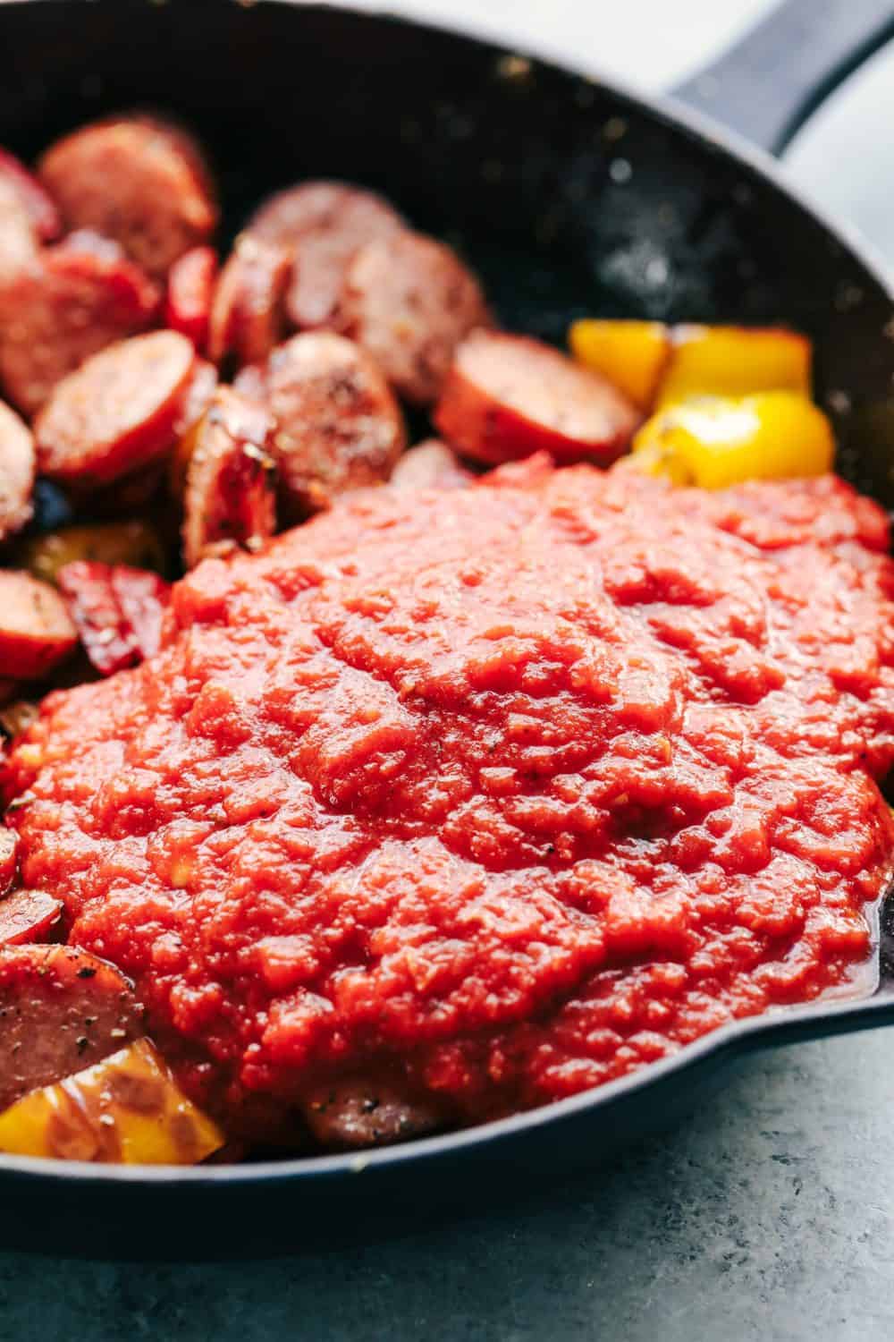 Rich tomato sauce being made in one skillet with Italian spices.