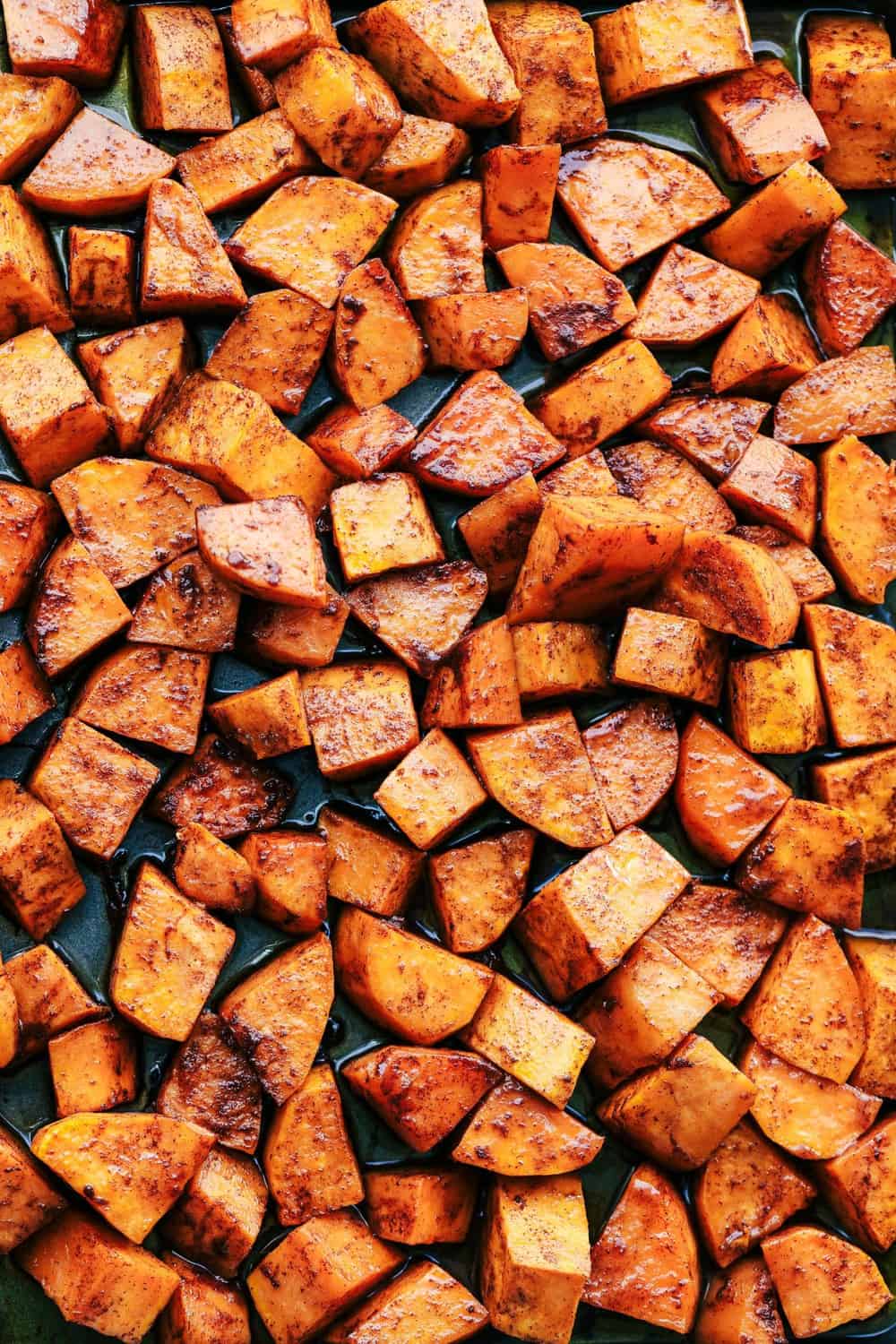 Roasted Honey Cinnamon Butter Sweet Potatoes spread out on a pan.