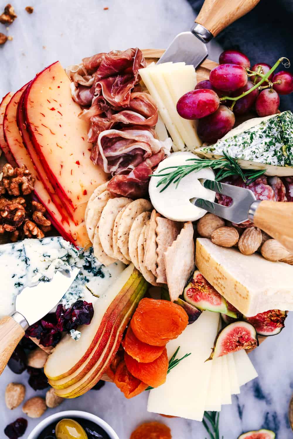 Cheese Board filled with meats, cheeses, nuts, and fruit. 