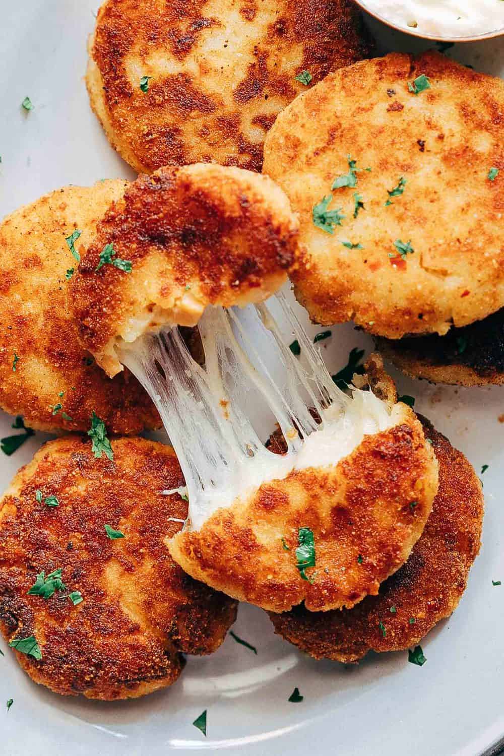 Stretchy cheesy shot of ham mashed potato cakes to show texture