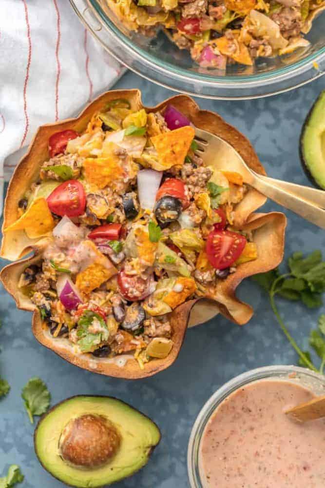 Creamy Taco Salad with a cut avocado and bean dip. 