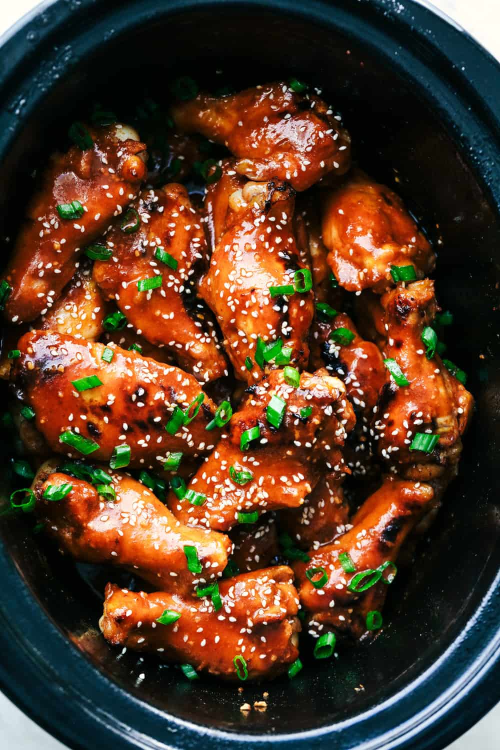 Slow Cooker Honey Garlic Sriracha Wings in a crock pot.