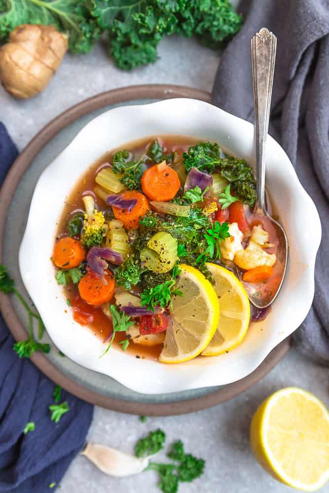 Vegetable detox soup served in a bowl with a spoon.