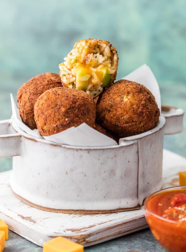 One Bacon Broccoli Cheese Arancini cut in half and stacked on others.