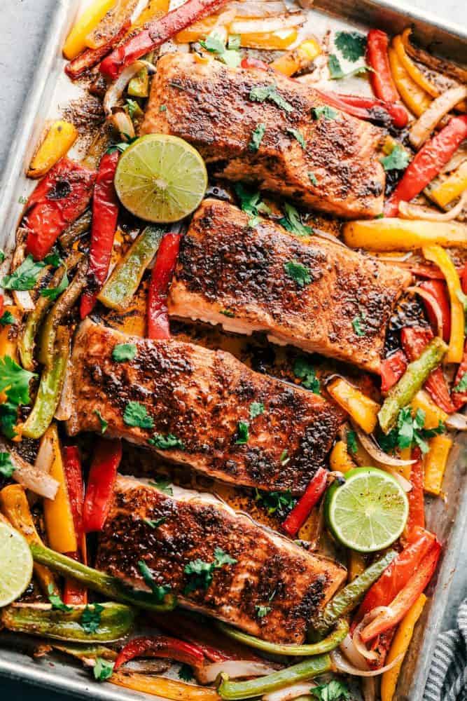 Cooked Sheet Pan Garlic Lime Salmon with sliced lime and sliced sweet peppers.