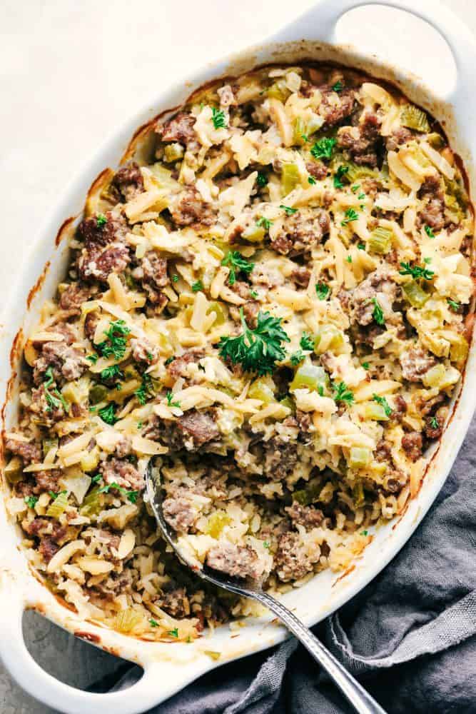 Easy Sausage and Rice Casserole in a white dish with a metal spoon. 