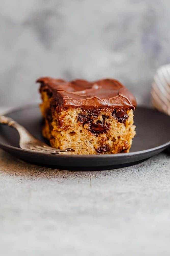 Chocolate Chip Banana Cake on a black plate with a fork