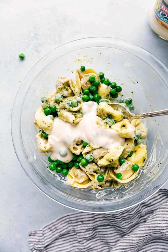 Alfredo Pesto Tortellini with Sausage in a clear bowl. 