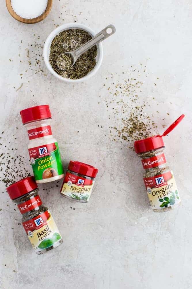 McCormick seasonings on a white table and a small dish of mixed seasonings. 