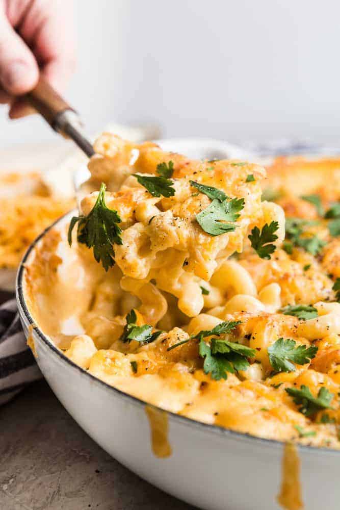 Baked Macaroni and Cheese being spooned out of a white pot. 