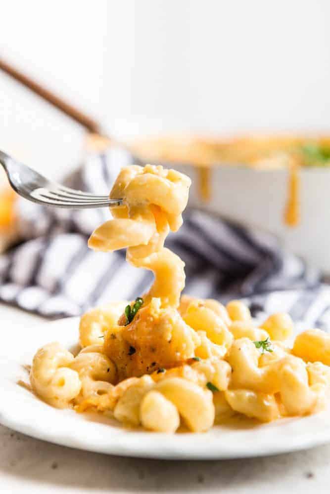 Baked Macaroni and Cheese on a white plate with a fork. 