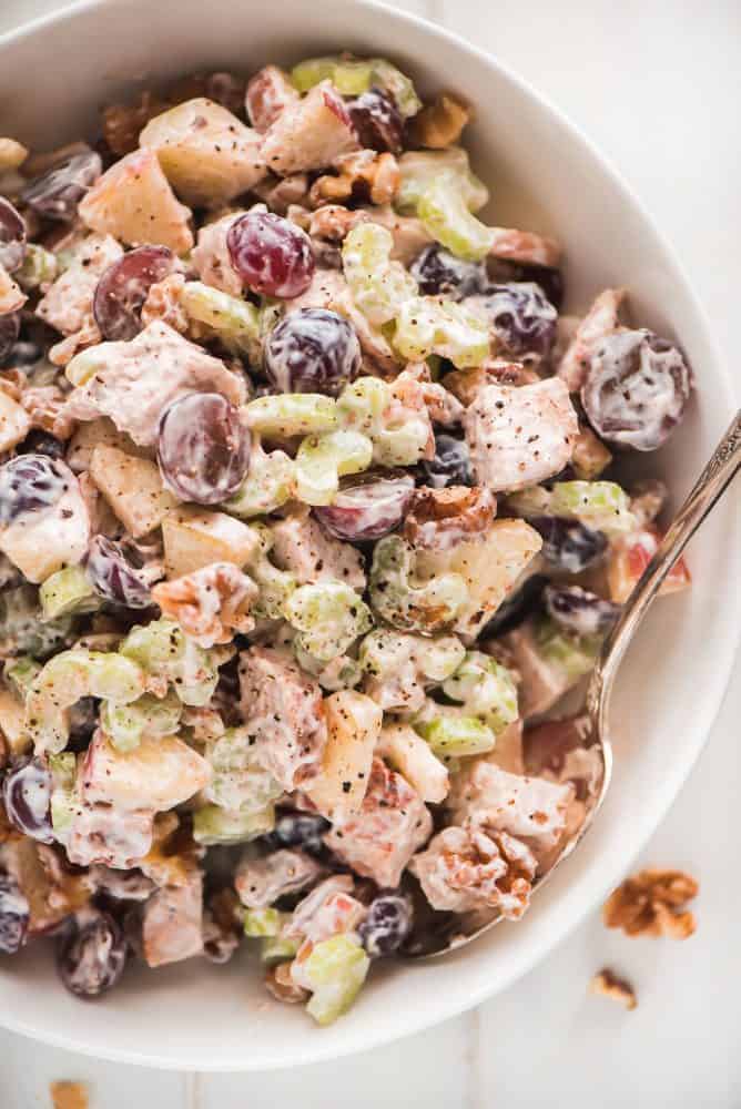 A large bowl of Waldorf Chicken Salad sprinkled with pepper.