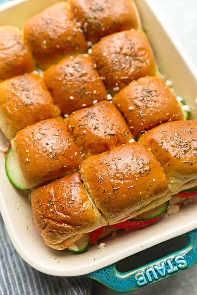 Greek Chicken Sliders in a white iron pan. 