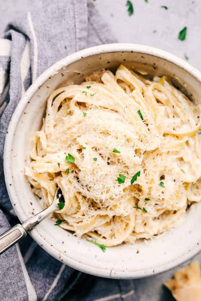 Asiago Garlic Alfredo Pasta with a fork and white bowl. 