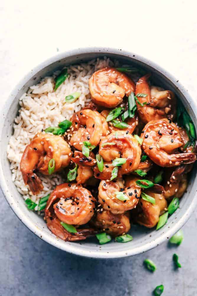 Sticky Sesame Garlic Shrimp over white rice in a white bowl. 