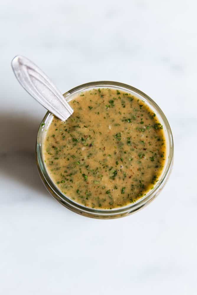 Chipotle dressing in a clear bowl with a spoon. 