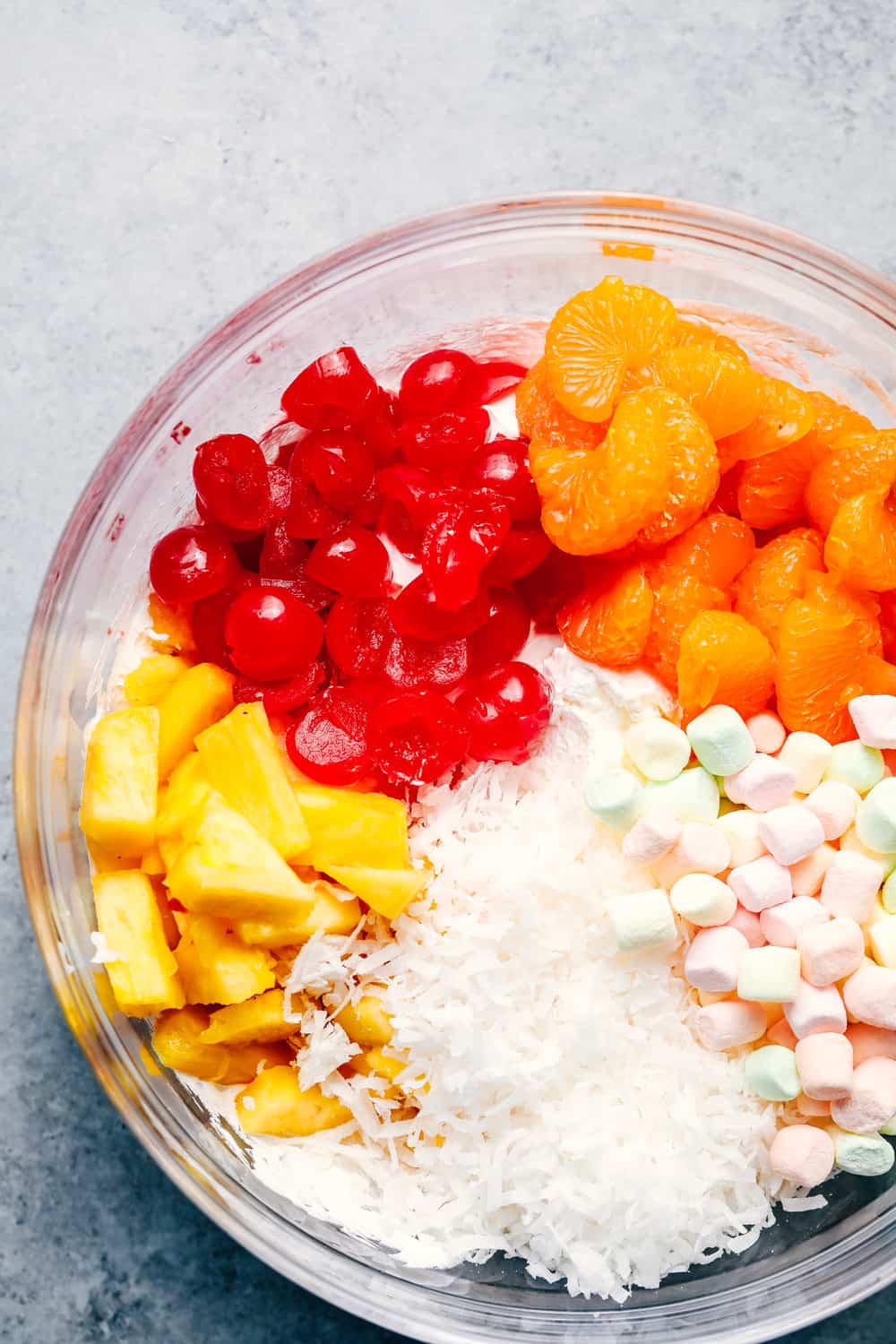 Ambrosia Salad ingredients in a glass bowl.