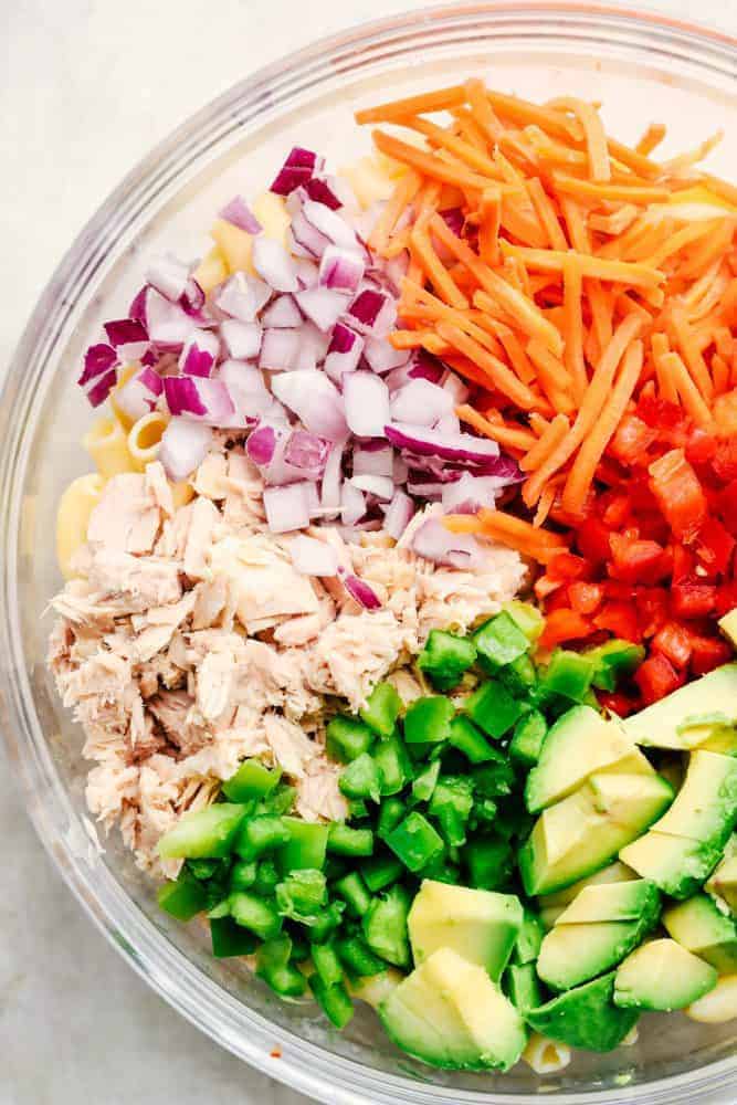 Ingredients for Tuna Avocado Macaroni Salad in a clear bowl. 