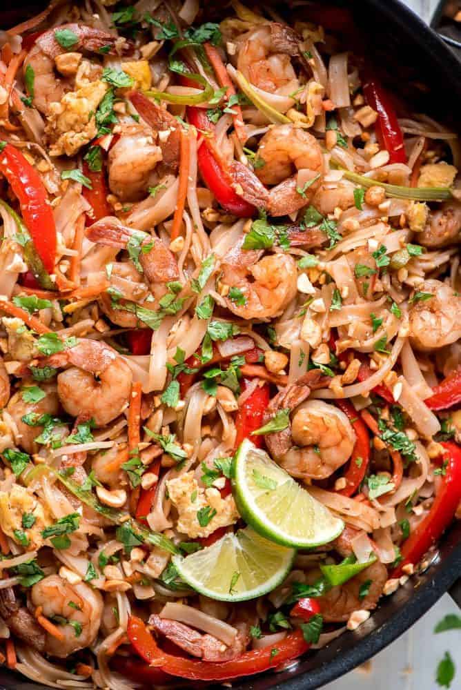 Close up of Shrimp Pad Thai in a black skillet. 