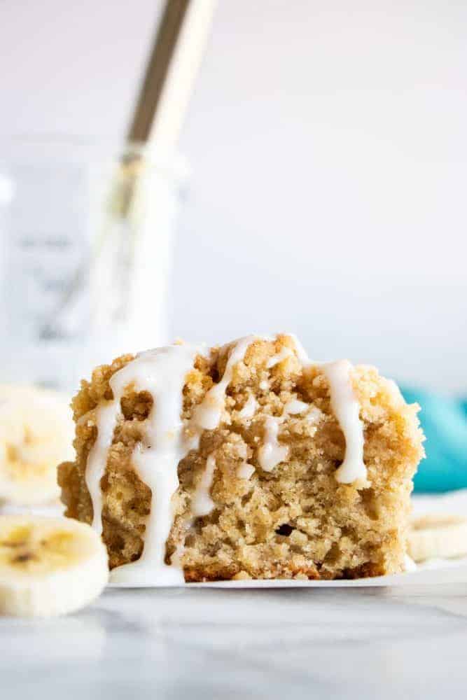 A slice of Banana Bread Crumb Cake with fresh cut bananas on the side. 