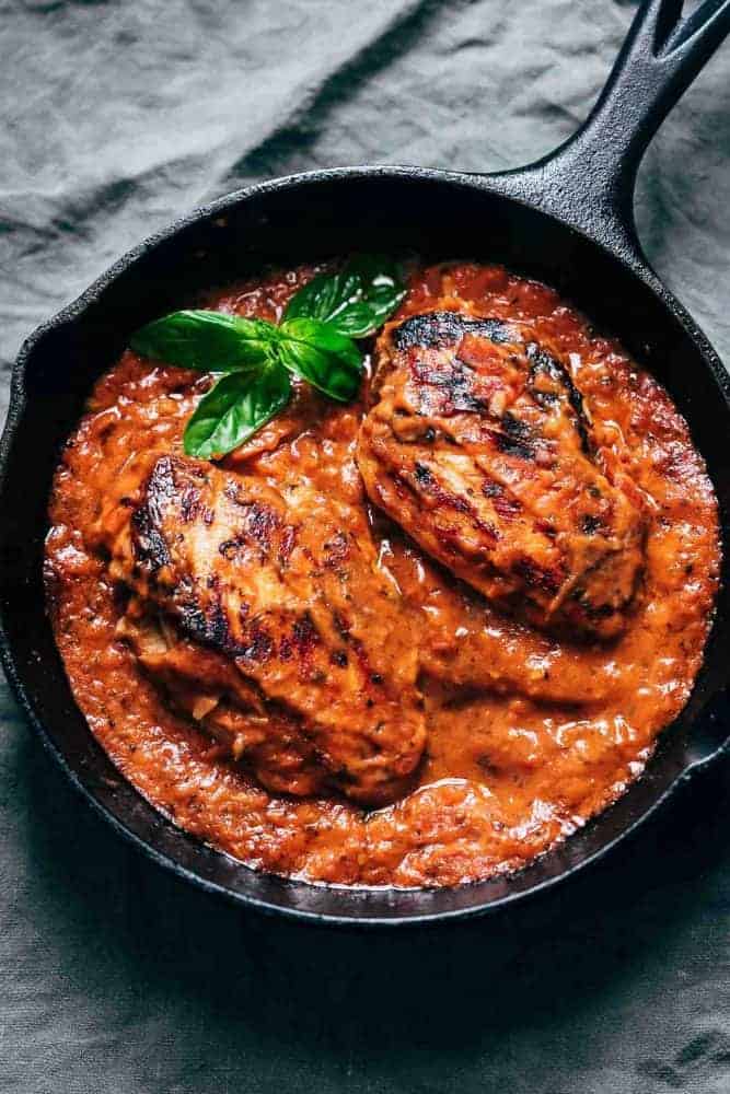 Creamy tomato basil chicken in a cast iron skillet ready to be served.