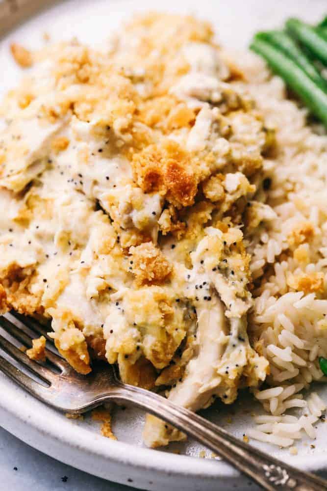 Poppyseed Chicken Casserole on a white plate with green beens on the side. 