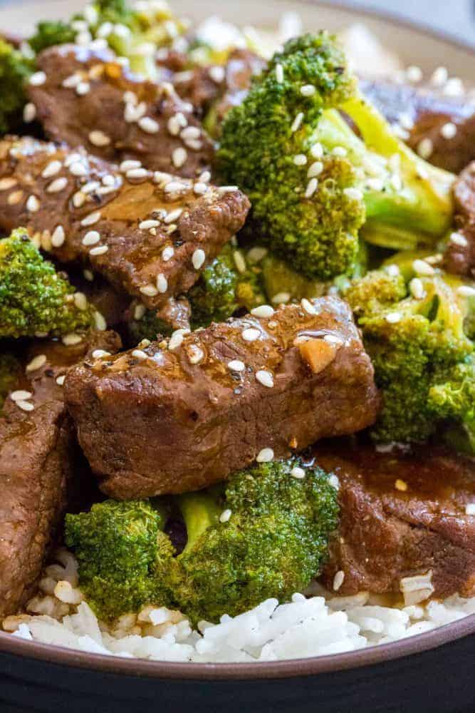 Close up photo of beef and broccoli topped with sesame seeds.