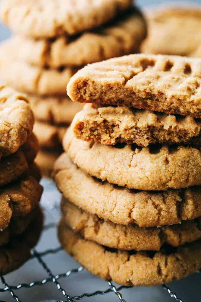 Peanut butter cookies stacked on top of each other on a cooling rack.