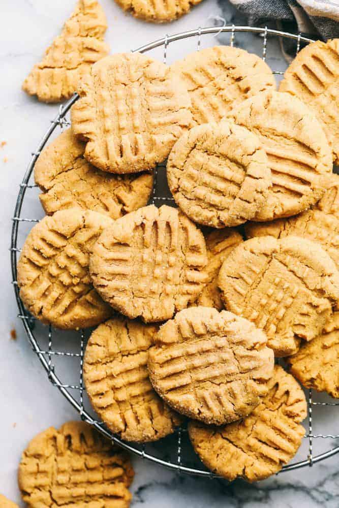 Several peanut butter cookies stacked on top of each other on a cooling rack.