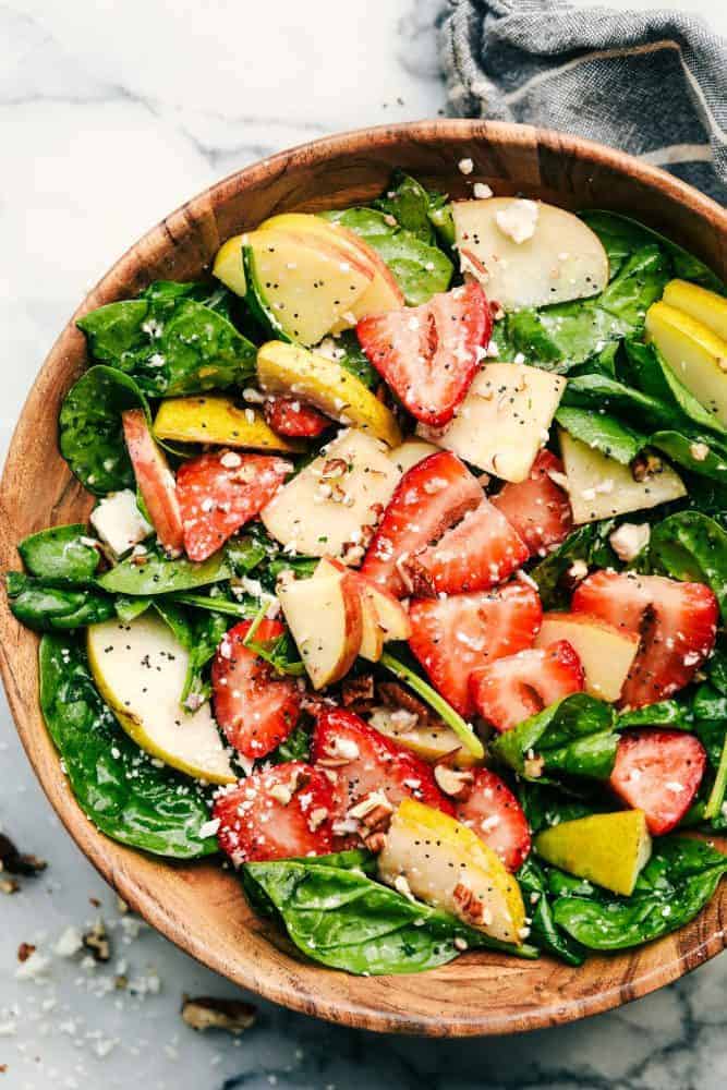 Strawberry, Apple, and Pear Spinach Salad in a wood bowl. 