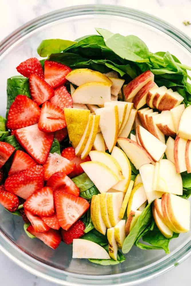 Strawberry, Apple, and Pear Spinach Salad ingredients in a bowl. 