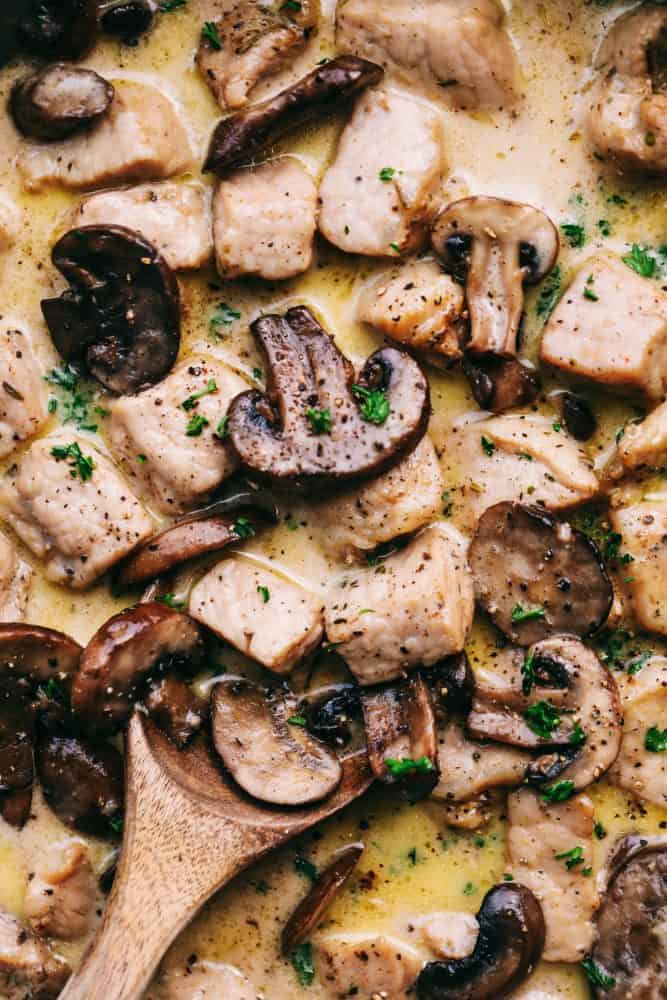 Close up of Creamy Garlic Pork Marsala with a wooden spoon. 