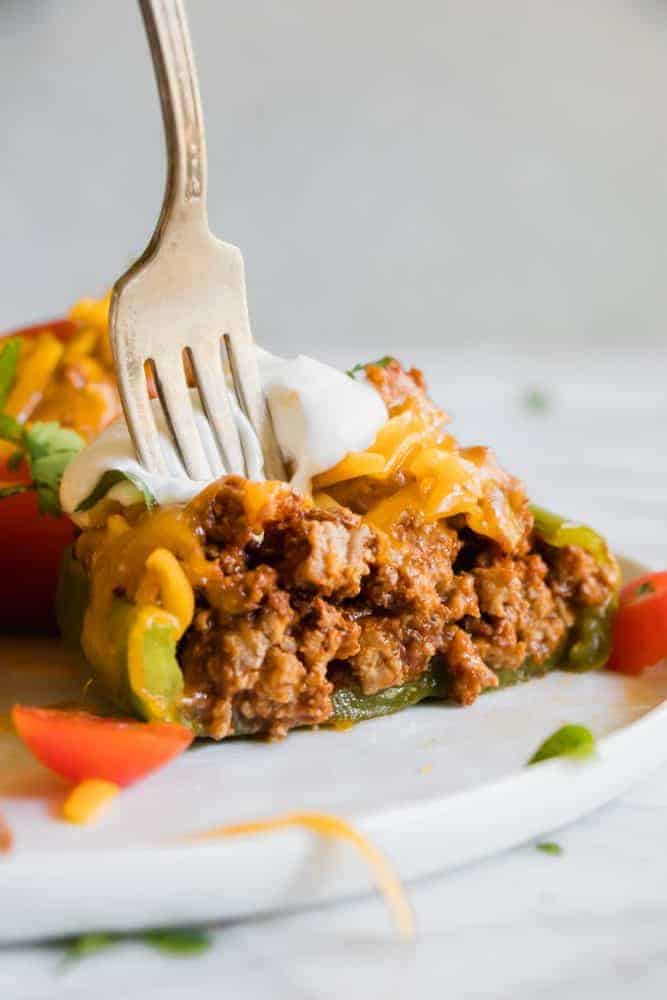 Taco Stuffed Pepper on a white plate with a fork. 