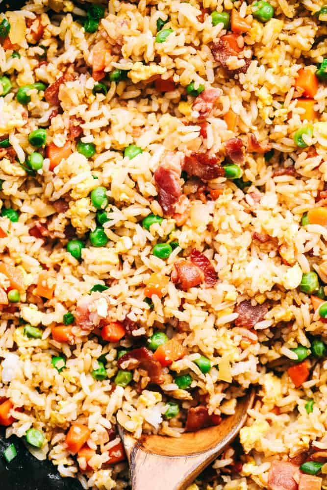 Close up of Bacon Fried Rice with a wooden spoon. 