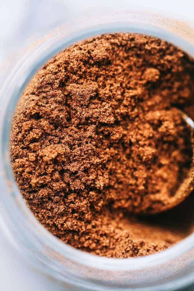 Close up of homemade pumpkin pie spice in a clear glass jar. 