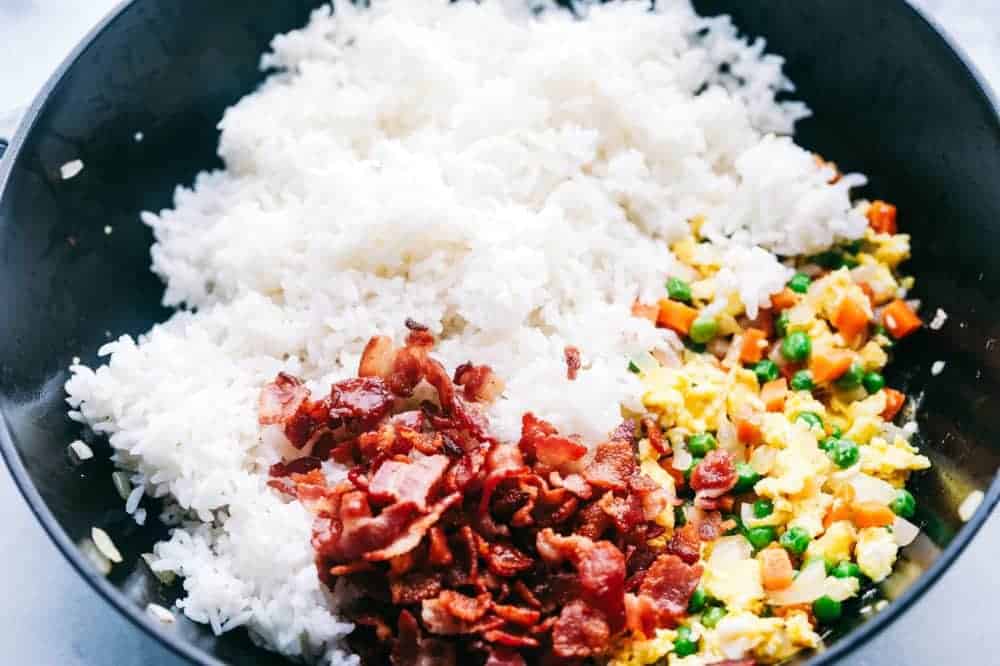 Ingredients of Bacon Fried Rice in a pan to be mixed during frying. 