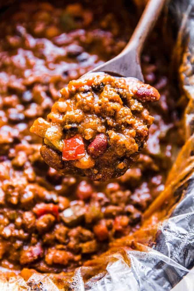 Slow cooker pumpkin chili with a wooden spoon.