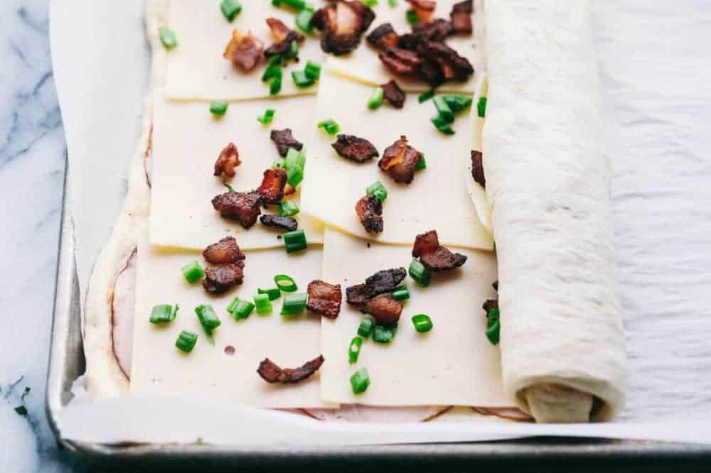 Ham and Swiss Stromboli being rolled up. 