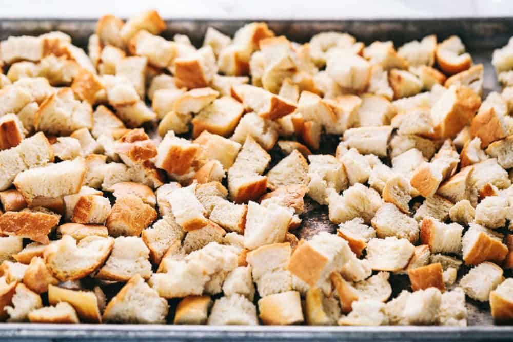 Chunks of bread on a baking sheet getting ready to be roasted to use in the Roasted autumn vegetable stuffing.