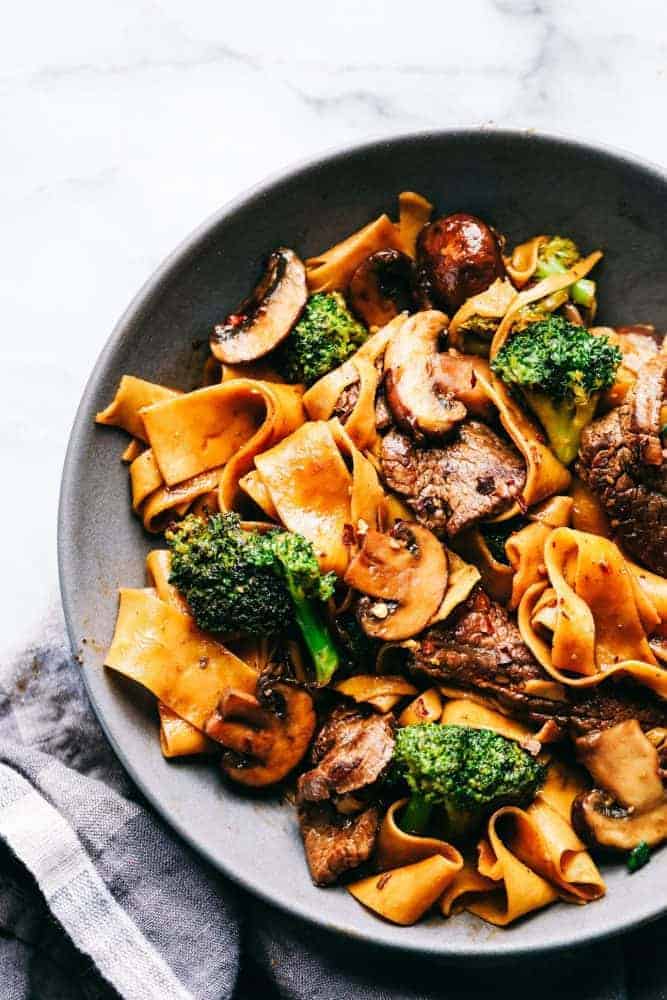 Garlic beef and broccoli noodles and a gray bowl.