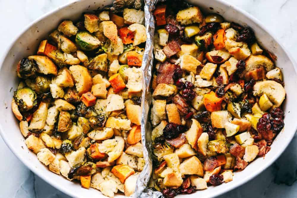 Roasted autumn vegetable stuffing and a white dish with an aluminum foil divider in the middle