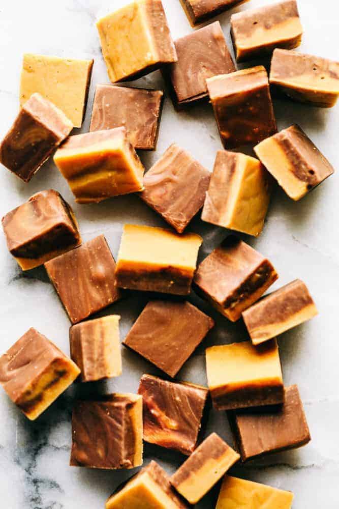 Peanut butter chocolate fudge scattered about on a granite countertop.