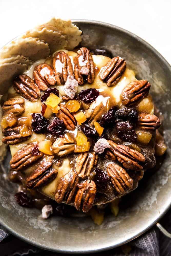 Maple pecan baked brie with chips on the side served in a dish.