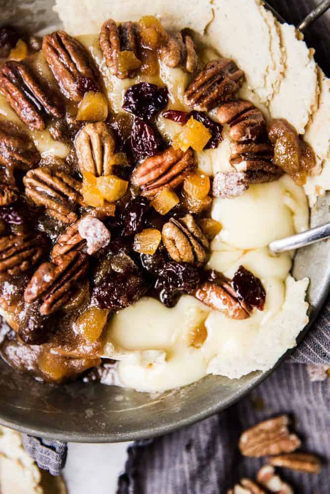 Maple pecan baked brie in a serving dish with chips on the side.