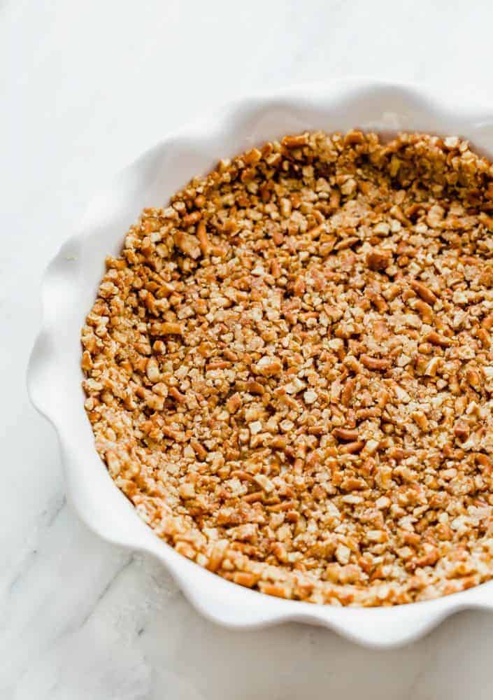 Peanut butter pie crust in a white pie pan.