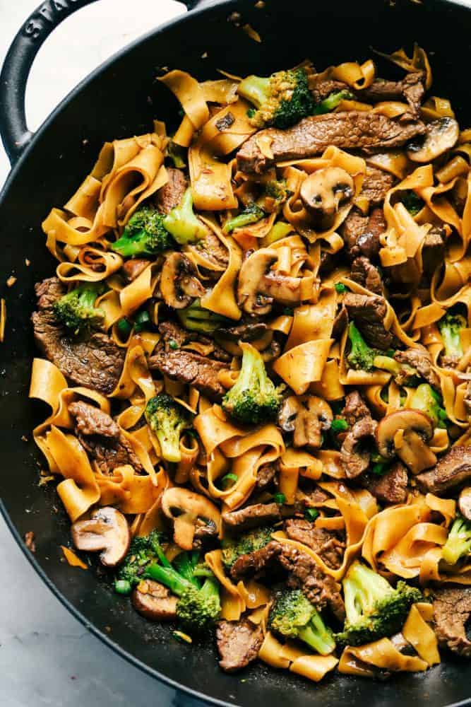 Garlic beef and broccoli noodles in a black skillet.