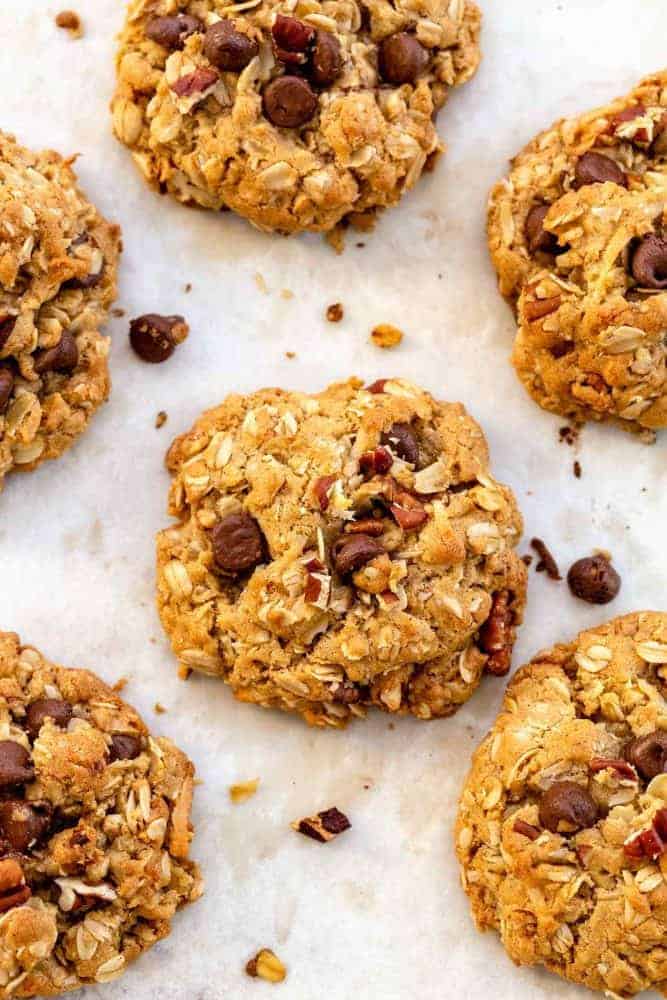 Baked cowboy cookies on a parchment paper lined sheet pan.